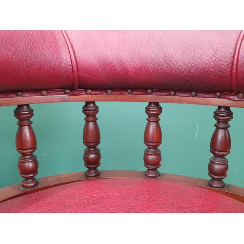 961 - A pair of mahogany and upholstered Library Chairs with carved backs and turned front supports, label... 