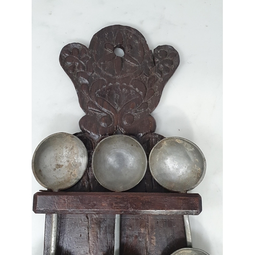 10 - An antique carved oak Spoon Rack 17in H with six pewter Spoons