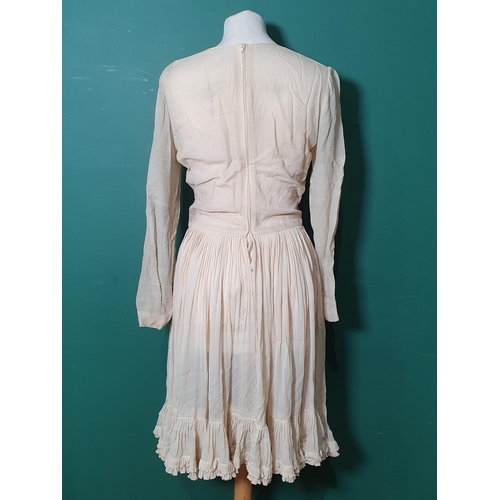 19 - A 1920's s type cream Dress with frilled bottom edge bearing Miss Dior label