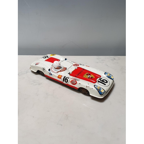 273 - A tinplate clockwork saloon Car and a tinplate Porsche Le Mans Car, both A/F (R8)