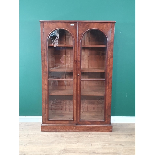 502 - A Victorian mahogany veneered Bookcase fitted pair of arched glazed doors enclosing adjustable shelv... 