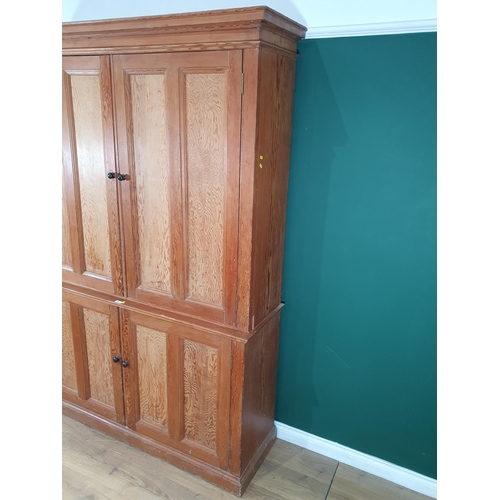 504 - A large pitch pine two piece Cupboard, with four panelled doors enclosing fitted shelve interior, 7f... 