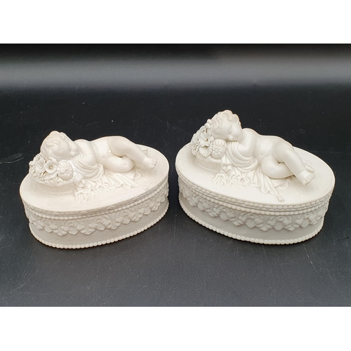 530 - A pair of antique Parianware oval lidded Boxes with putti handles (restored) and three other parian ... 