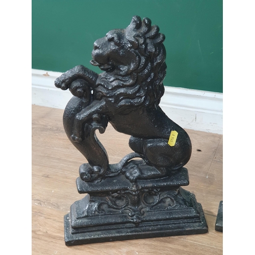 630 - Three black painted cast iron Doorstops in the form of rearing lions 14in H (R7)