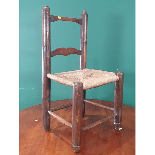 67 - An primitive pine child's Chair with rush seat 2ft 7in H (R9)