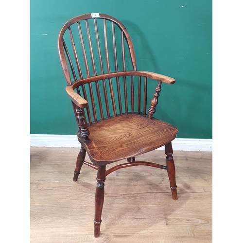 68 - An antique ash and yew stick back Windsor Elbow Chair raised on turned supports united with crinolin... 