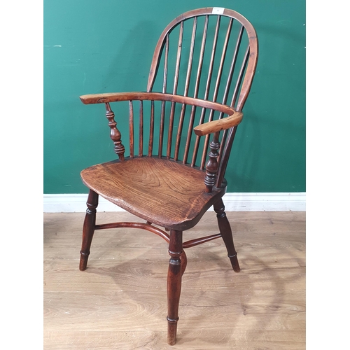 68 - An antique ash and yew stick back Windsor Elbow Chair raised on turned supports united with crinolin... 