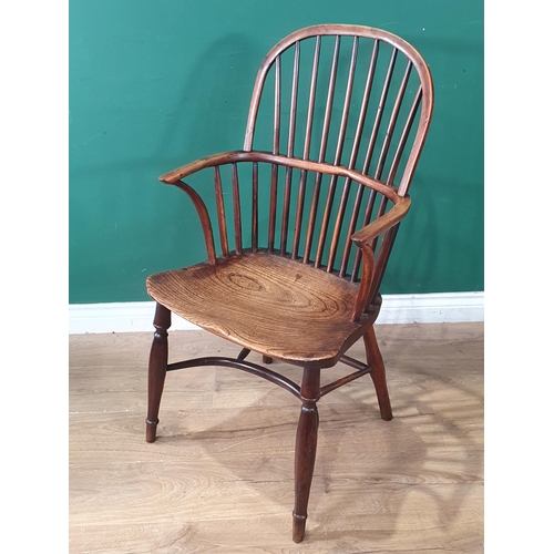 703 - A 19th Century ash and yew stick back Windsor Elbow Chair on slim turned supports united by crinolin... 