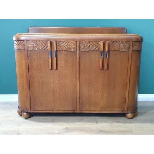 85 - An Art Deco oak Sideboard fitted four cupboard doors with carved decoration 4ft 4in W x 3ft 3in H (R... 