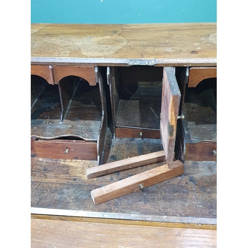 86 - A Georgian oak Bureau with fall front above two short and three long drawers mounted on bracket feet... 