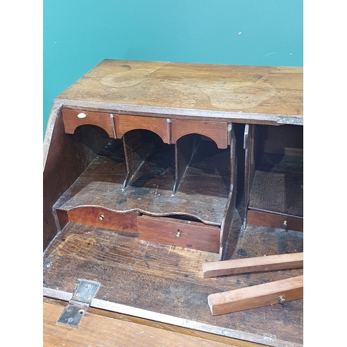 86 - A Georgian oak Bureau with fall front above two short and three long drawers mounted on bracket feet... 