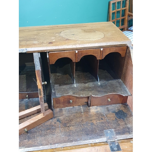 86 - A Georgian oak Bureau with fall front above two short and three long drawers mounted on bracket feet... 