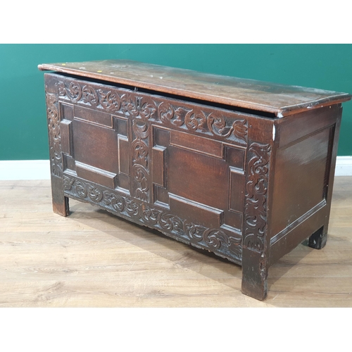 87 - A 17th Century oak Coffer with tulip and leafage carving surrounding two geometric moulded panels A/... 