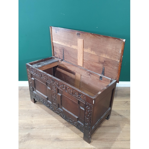 87 - A 17th Century oak Coffer with tulip and leafage carving surrounding two geometric moulded panels A/... 