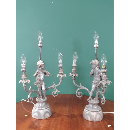 677 - A pair of metal three branch Table Lamps with cherub supports 2ft 1in H (R4)(Passed PAT)