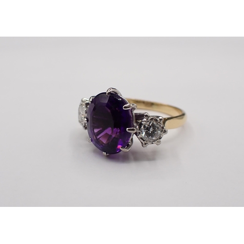 152 - An Amethyst and Diamond three stone Ring claw-set oval mixed-cut amethyst between two brilliant-cut ... 