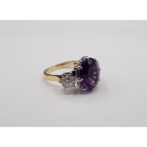 152 - An Amethyst and Diamond three stone Ring claw-set oval mixed-cut amethyst between two brilliant-cut ... 