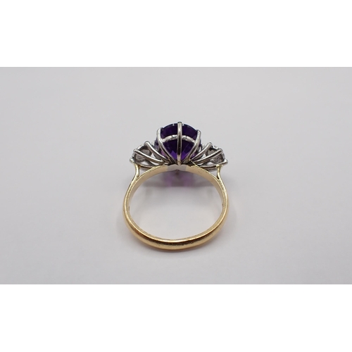 152 - An Amethyst and Diamond three stone Ring claw-set oval mixed-cut amethyst between two brilliant-cut ... 