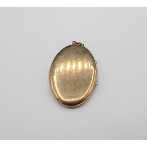 162 - A 9ct gold oval Locket with scroll engraving to front, approx 12.20gms