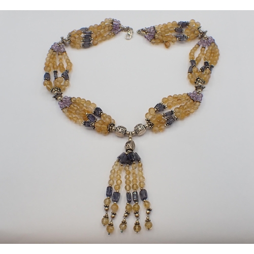 173 - A Citrine, Iolite and Amethyst five strand bead Necklace with central tassel drop on clasp marked 92... 