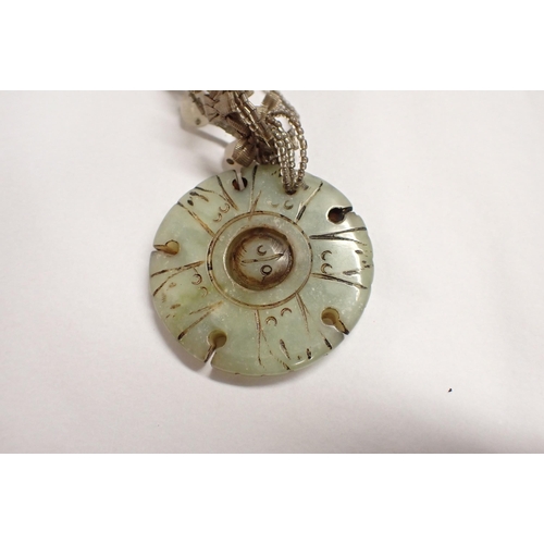 213 - A jade type circular Pendant with rotating centre disc, approx 48mm diameter