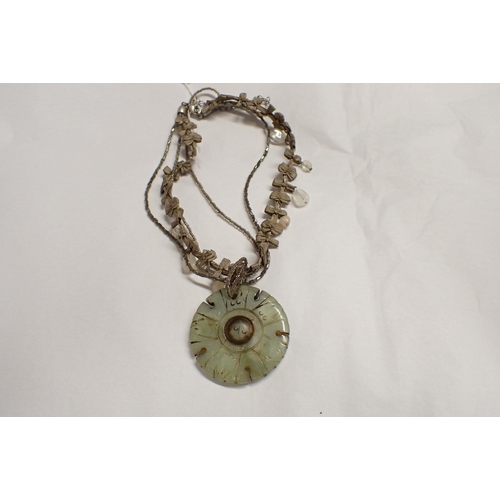 213 - A jade type circular Pendant with rotating centre disc, approx 48mm diameter