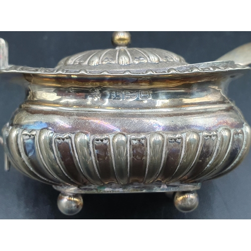 126 - An Edward VII silver oval Mustard Pot, Chester 1909, with blue glass liner and spoon, and a boat sha... 