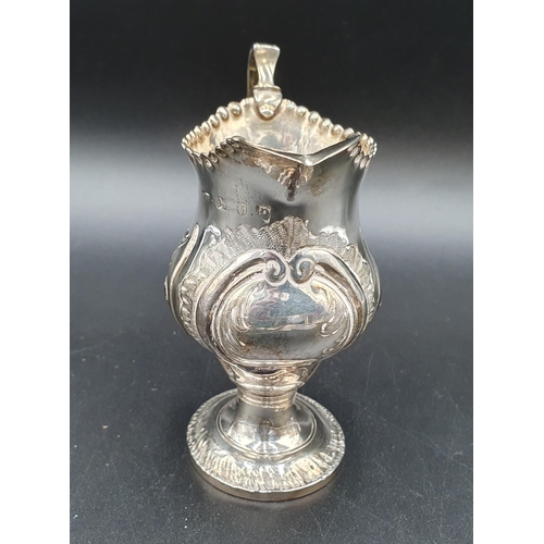 131 - A George III silver Cream Jug with later floral embossing on pedestal base, London circa 1770