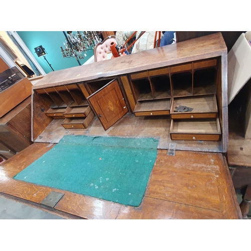 239 - A 19th Century oak and mahogany cross banded Bureau fitted two short and three long drawers, lacking... 