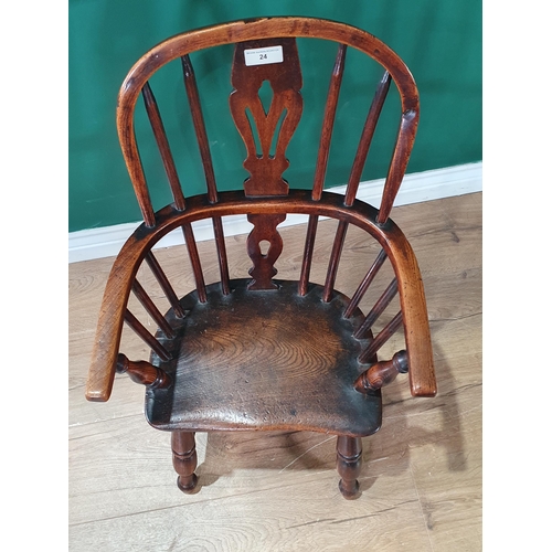 24 - An antique ash and elm child's Windsor Elbow Chair with pierced splat back, and raised on turned sup... 