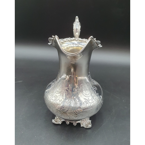 289 - A Victorian silver baluster Jug with flora land scroll engraving, leafage scroll handle on scroll fe... 