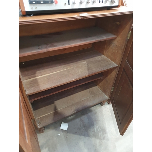 47 - An antique oak Kitchen Cupboard fitted pair of fielded panel doors enclosing shelves raised on turne... 