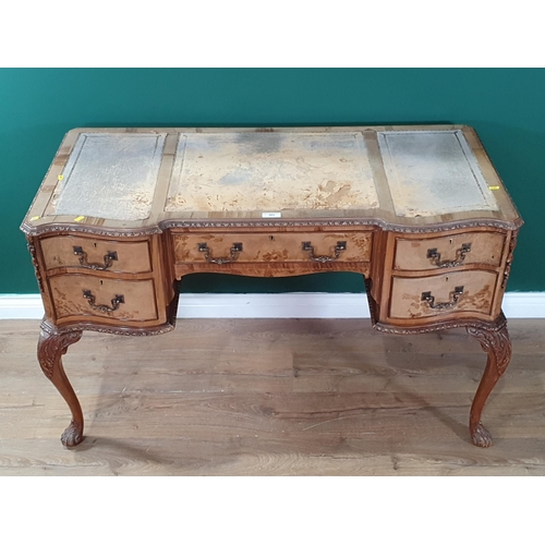 483 - A French style reproduction walnut veneered Serpentine fronted Desk, with inset tooled writing surfa... 