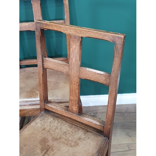 613 - A set of four oak Arts and Crafts style Chairs with leather drop in seats on chamfered squared suppo... 