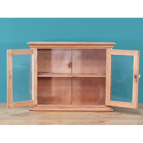 628 - A small beech glazed two door Cabinet, 2ft W x 18in H (R7)