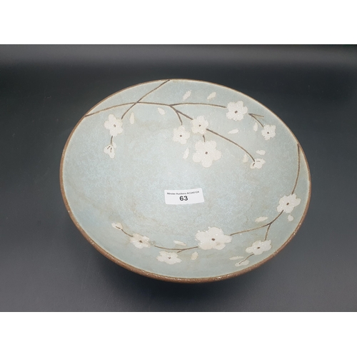 63 - An Art Pottery Bowl decorated flowering shrub on a pale blue ground, 9 1/2in diam, square signature ... 