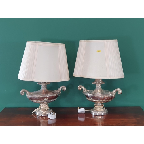 636 - A pair of Silver plated Table Lamps in the form of Urns with scrolled decoration and weighted bases,... 