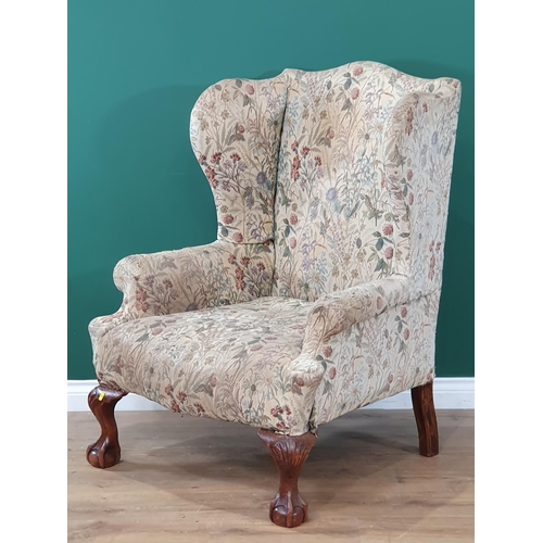 643 - A Georgian style floral upholstered winged Armchair on ball and claw feet