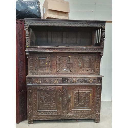 679 - An antique carved oak Tridarn with open bars to the sides of the upper section, fitted a pair of cup... 