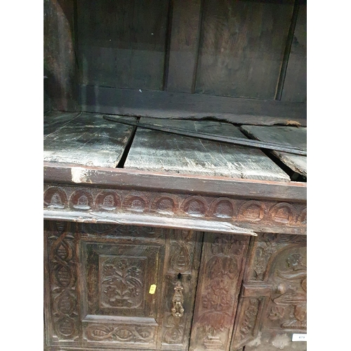 679 - An antique carved oak Tridarn with open bars to the sides of the upper section, fitted a pair of cup... 