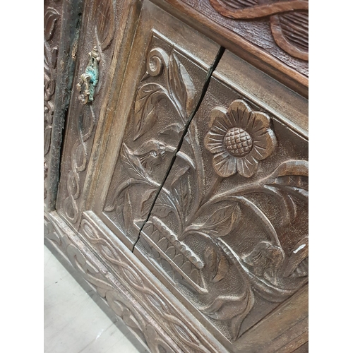 679 - An antique carved oak Tridarn with open bars to the sides of the upper section, fitted a pair of cup... 