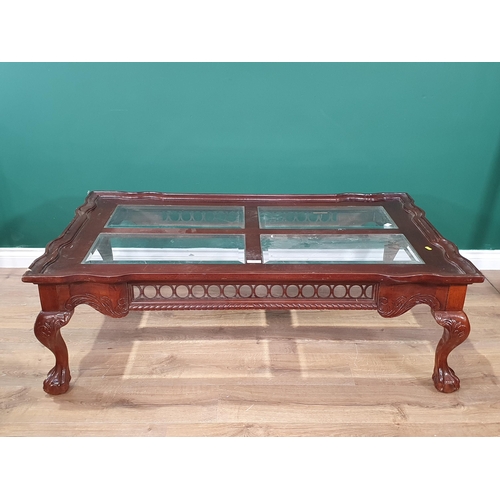 688 - A reproduction mahogany glass topped Coffee Table on claw and ball supports, A/F, 17