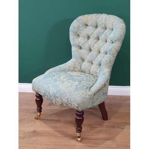 694 - A modern blue/green upholstered button back Nursing Chair with leafage designs, on turned front supp... 