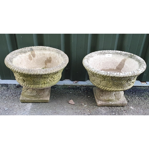 702 - A pair of Sandford low Garden Urns with moulded floral designs on pedestal bases, A/F, (Corner of Pe... 