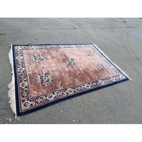 722 - A Chinese Rug with floral and scrolled border and with floral designs on a beige ground, 10ft 4in x ... 