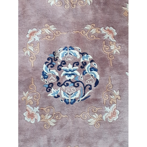 722 - A Chinese Rug with floral and scrolled border and with floral designs on a beige ground, 10ft 4in x ... 