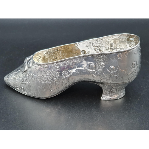 94 - A large Continental silver Shoe embossed numerous cupids playing in a landscape, Import mark London ... 