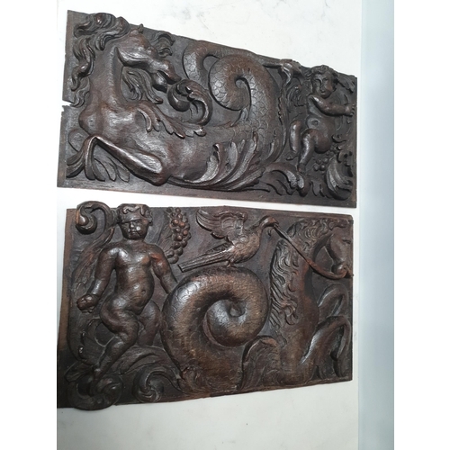 32 - A pair of 17th century oak Panels with carved seahorse and cherubs, 17in x 8 1/2in, and 16 1/2 in x ... 