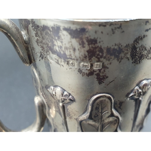 102 - A George V Art Nouveau silver Christening Mug  with leafage and floral embossing, Birmingham 1912