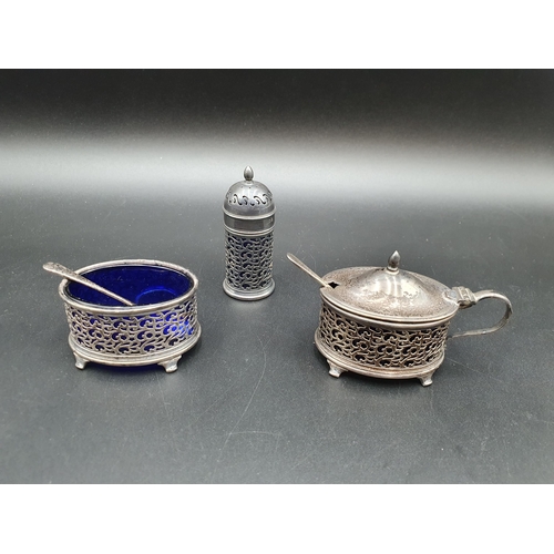 111 - A George V silver three piece Condiment Set with pierced design and blue glass liners, and two Spoon... 